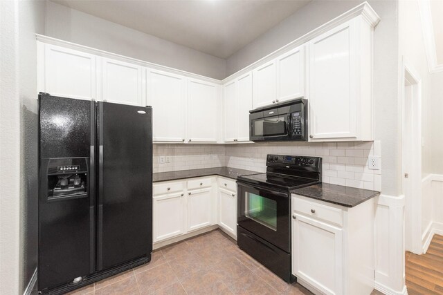 kitchen with decorative backsplash, white cabinets, dark stone counters, and black appliances