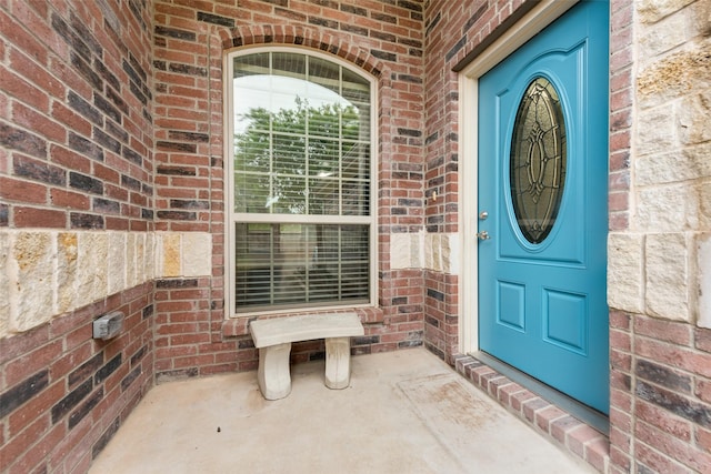 view of exterior entry featuring brick siding