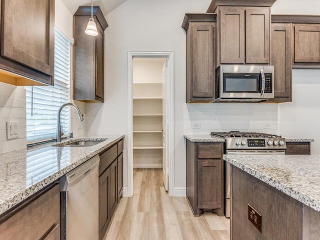 2012 Ranchwood Dr, Wylie, TX 75098 - kitchen featuring stainless steel appliances, a sink, light wood-style floors, and tasteful backsplash