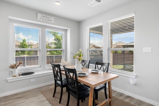 dining area featuring baseboards, light wood-style flooring, and visible vents