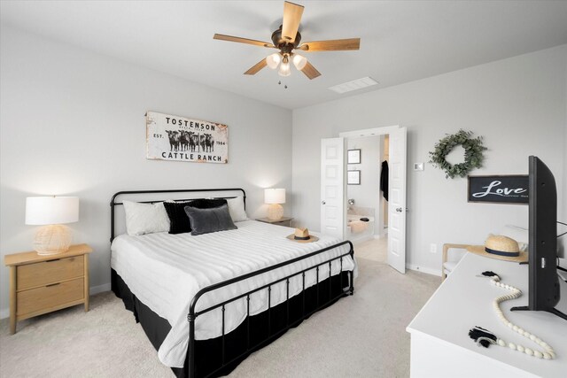 bedroom with connected bathroom, light colored carpet, a ceiling fan, baseboards, and visible vents