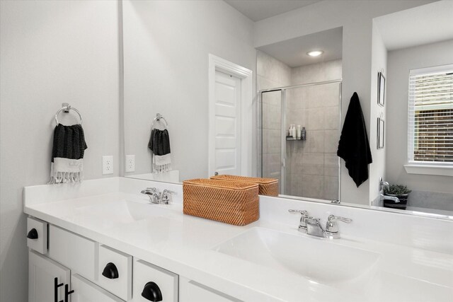 bathroom featuring double vanity, a shower stall, and a sink