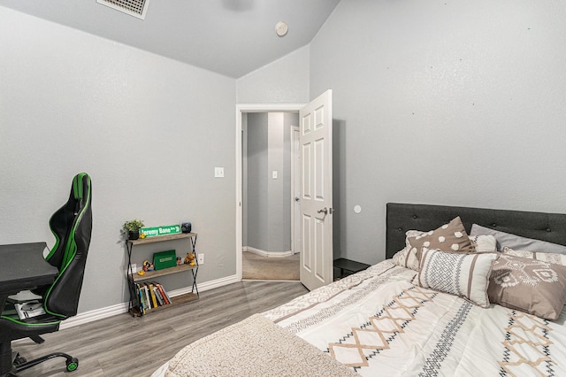 303 Valley View Ct, Rio Vista, TX 76093 - bedroom with lofted ceiling, baseboards, visible vents, and wood finished floors