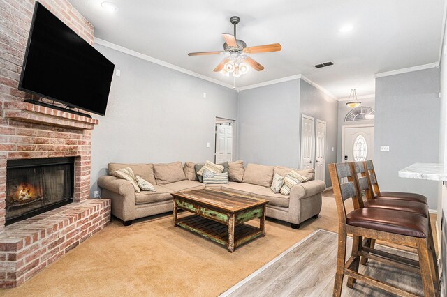 303 Valley View Ct, Rio Vista, TX 76093 - living area with visible vents, crown molding, light wood finished floors, a brick fireplace, and a ceiling fan