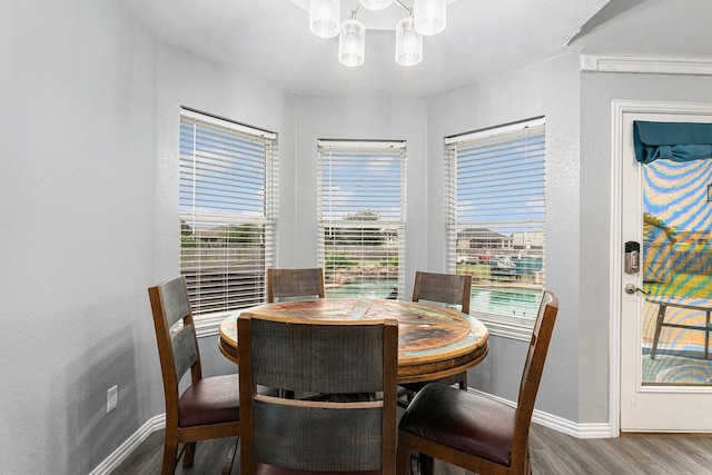 303 Valley View Ct, Rio Vista, TX 76093 - dining room featuring an inviting chandelier, baseboards, a healthy amount of sunlight, and wood finished floors