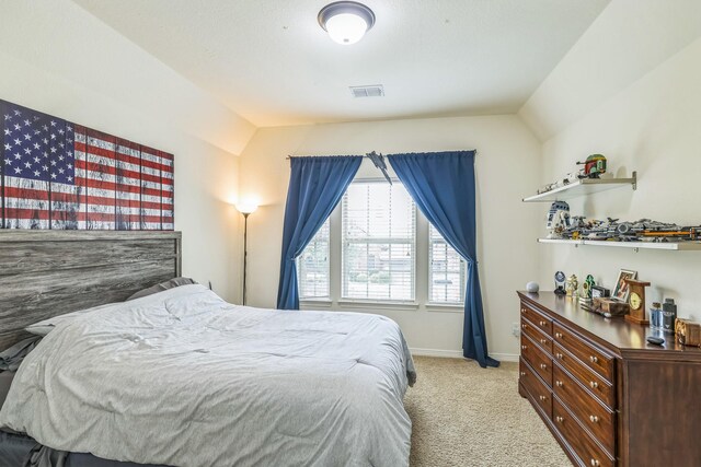 bedroom with light colored carpet, baseboards, visible vents, and lofted ceiling