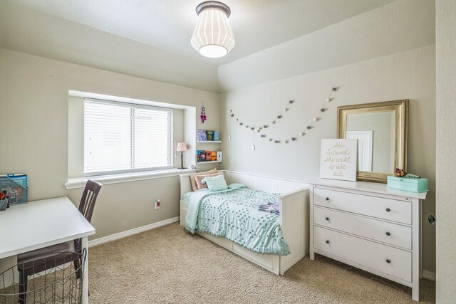 bedroom with light colored carpet and baseboards