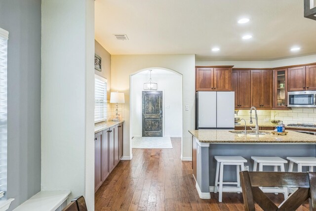 kitchen with visible vents, a sink, decorative backsplash, and stainless steel appliances