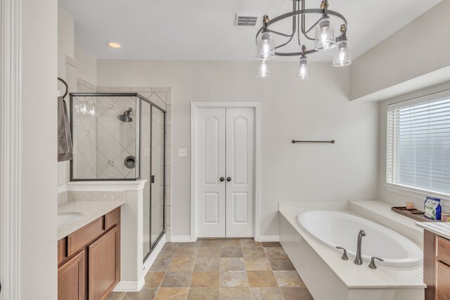 bathroom with vanity, baseboards, visible vents, a bath, and a stall shower