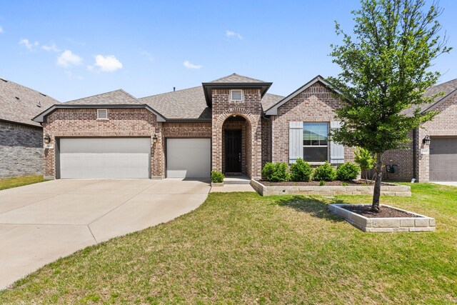 view of front of house featuring brick siding, a garage, a front yard, and a shingled roof