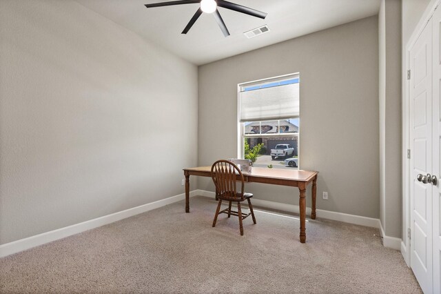 office area featuring a ceiling fan, baseboards, visible vents, and light carpet
