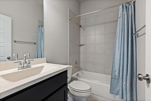 bathroom featuring vanity, toilet, a textured wall, and shower / tub combo
