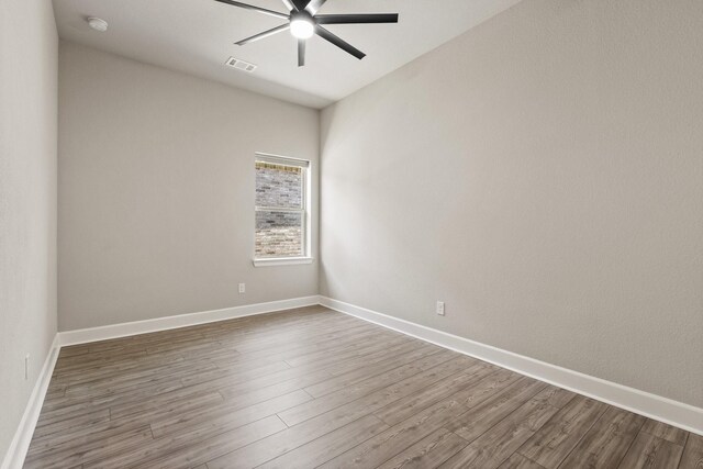 spare room with visible vents, baseboards, ceiling fan, and wood finished floors