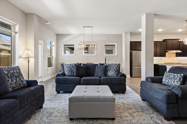 living area featuring recessed lighting, wood finished floors, and visible vents