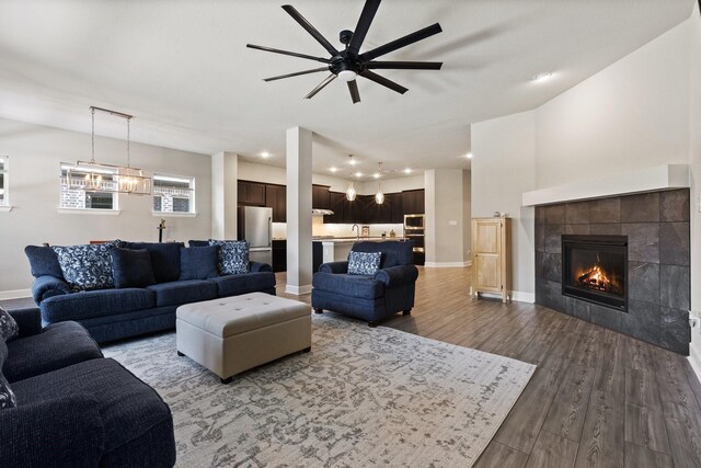 living room with baseboards, ceiling fan, wood finished floors, and a fireplace