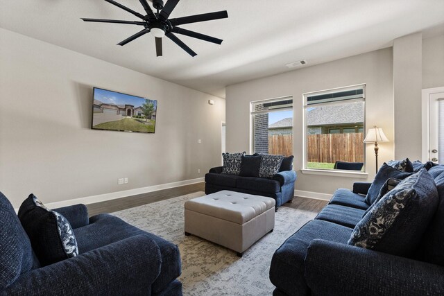 living area with visible vents, baseboards, ceiling fan, and wood finished floors