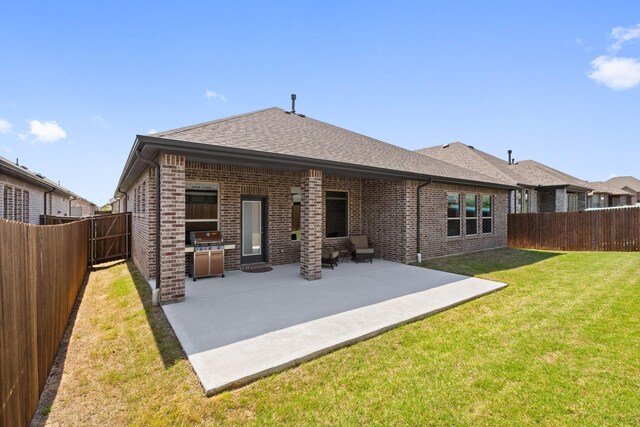 back of house featuring a patio, a fenced backyard, brick siding, a shingled roof, and a yard