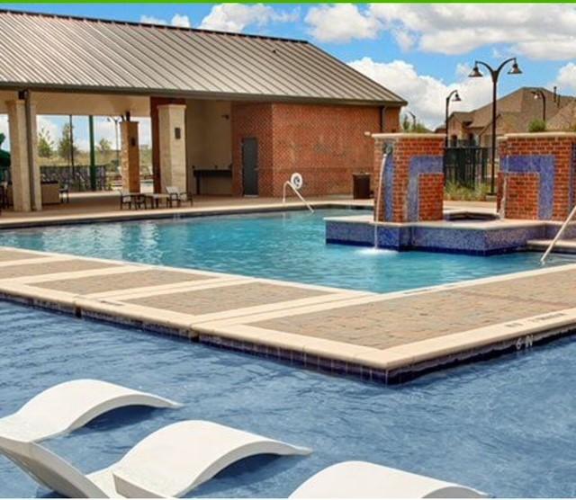 community pool featuring fence and a patio