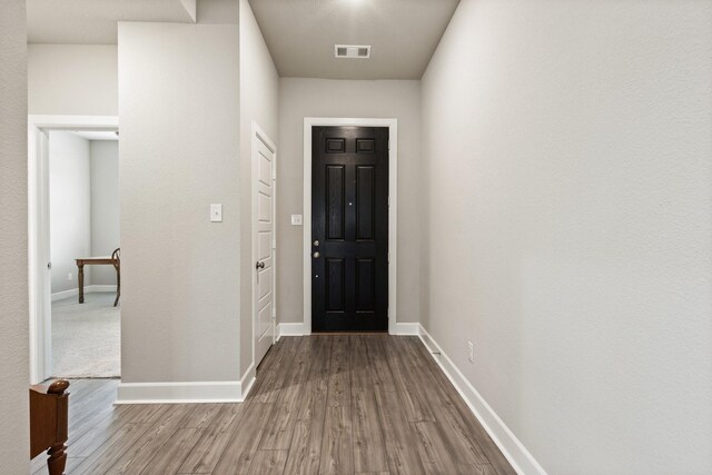 interior space with visible vents, baseboards, and wood finished floors
