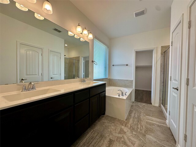bathroom with visible vents, double vanity, a bath, a shower stall, and a sink