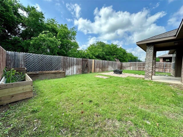view of yard featuring a fire pit and a fenced backyard