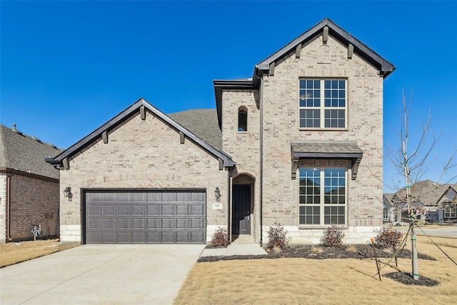 french country style house featuring brick siding, a garage, and concrete driveway