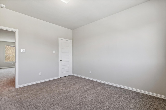 spare room with baseboards and carpet