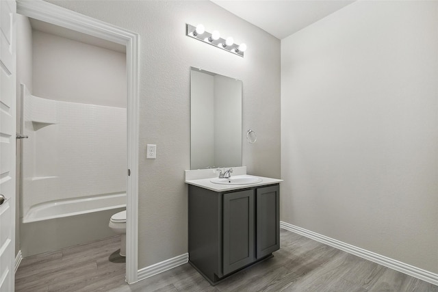 bathroom featuring vanity, baseboards, toilet, and wood finished floors