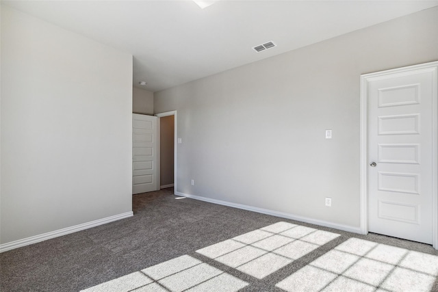 empty room with carpet floors, baseboards, and visible vents