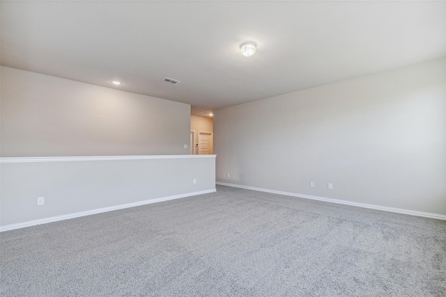 spare room with visible vents, carpet, and baseboards