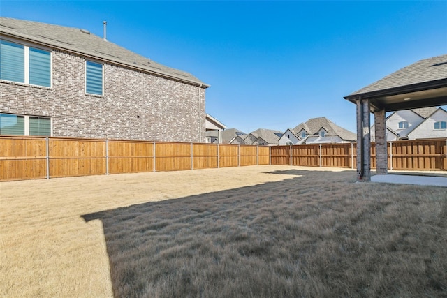 view of yard featuring a fenced backyard and a residential view
