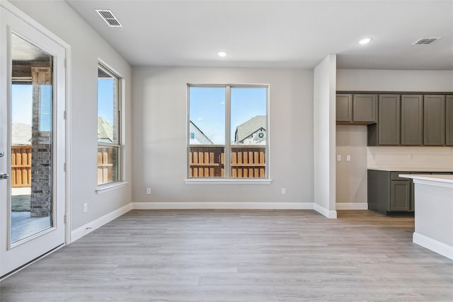 interior space featuring light countertops, recessed lighting, light wood-style flooring, and visible vents