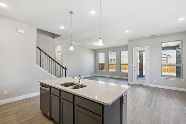 kitchen with stainless steel dishwasher, baseboards, a sink, and light wood-style flooring