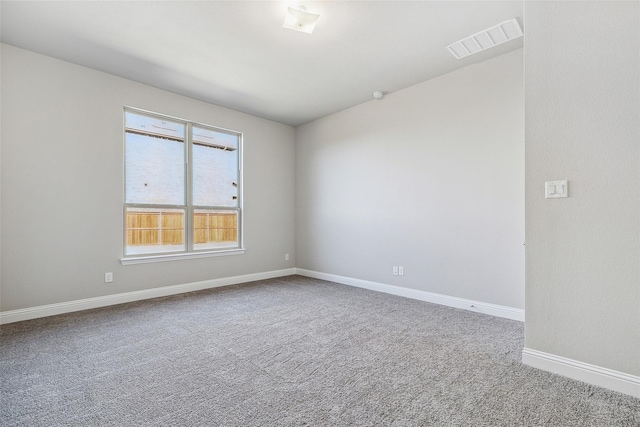 unfurnished room with visible vents, carpet, and baseboards