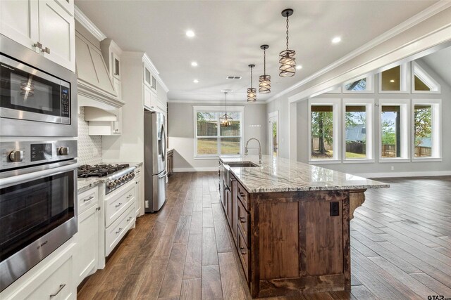 12090 Hackberry Holw, Tyler, TX 75706 - kitchen with crown molding, a sink, stainless steel appliances, baseboards, and dark wood-style floors