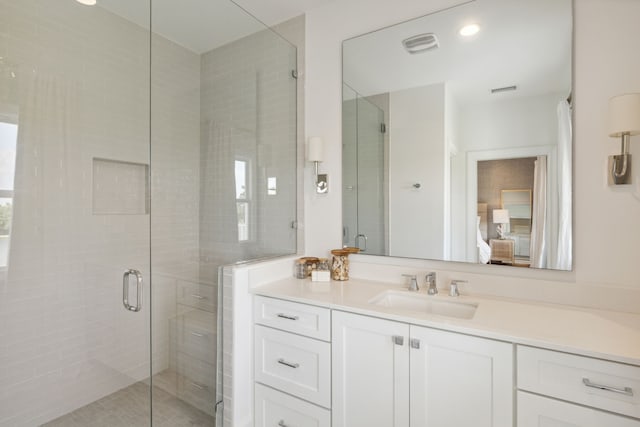 ensuite bathroom featuring vanity, ensuite bath, and a shower stall