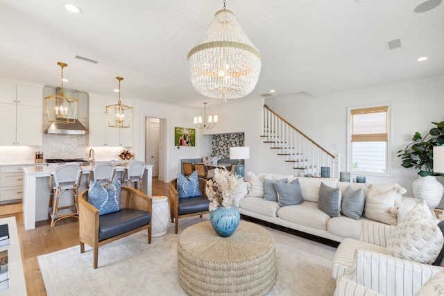 living room with visible vents, recessed lighting, light wood-style flooring, and a chandelier