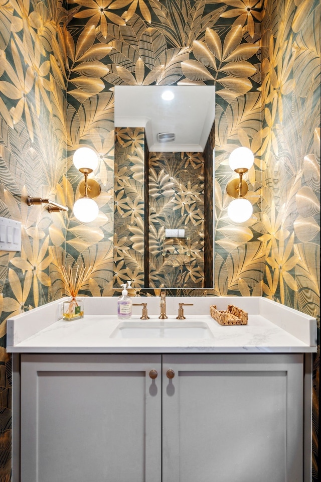 bathroom featuring vanity and wallpapered walls