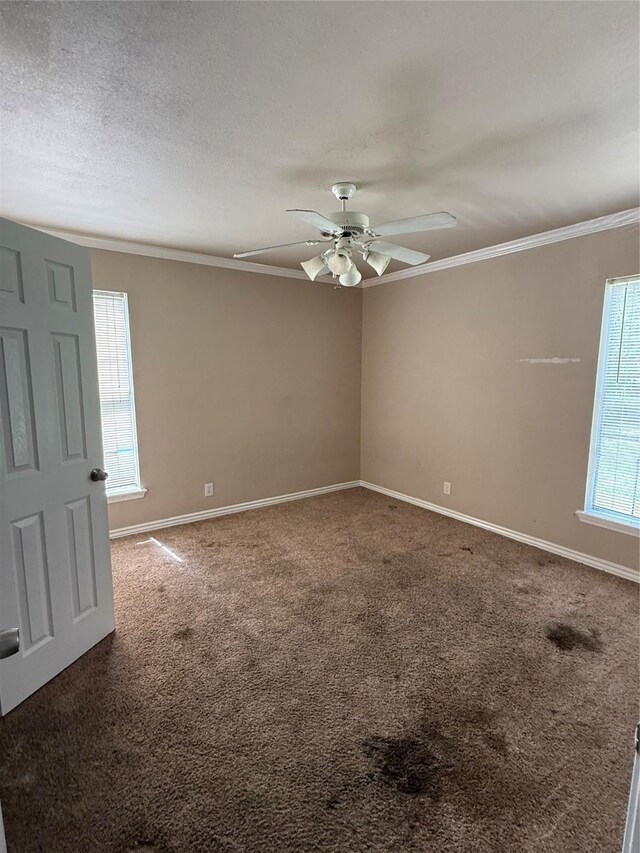 carpeted spare room featuring crown molding, a ceiling fan, and baseboards
