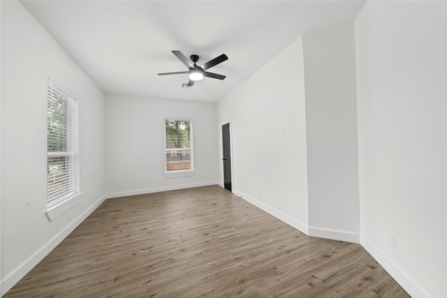 spare room featuring baseboards, a ceiling fan, and wood finished floors