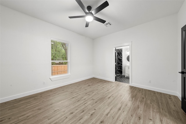 unfurnished bedroom featuring visible vents, baseboards, ensuite bathroom, and wood finished floors