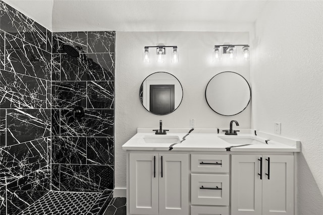 bathroom featuring double vanity, a sink, and a marble finish shower