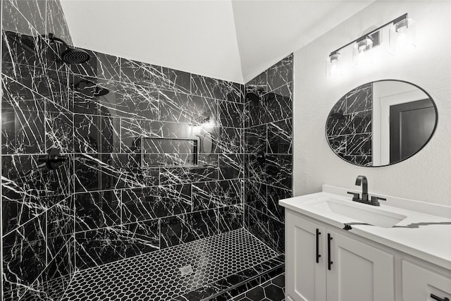 full bathroom with vanity and tiled shower