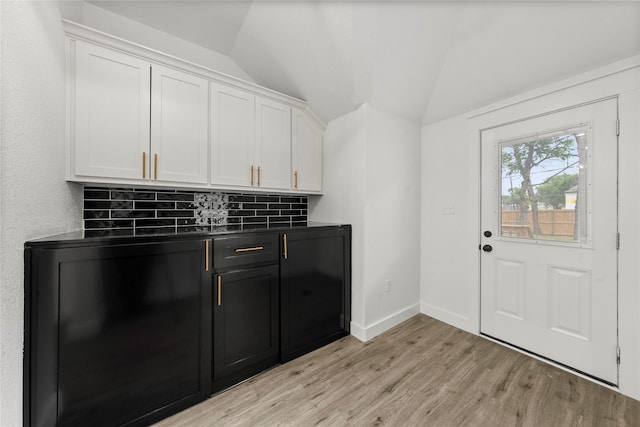 laundry area with light wood-type flooring and baseboards