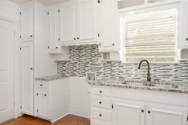 5524 Korth St, Sansom Park, TX 76114 - kitchen with a sink, decorative backsplash, white cabinetry, and light stone countertops