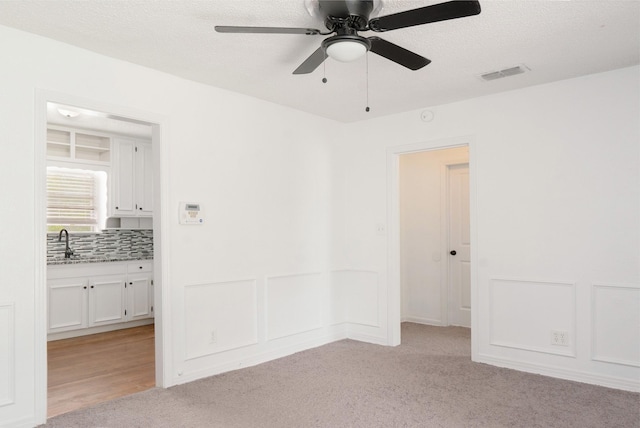 5524 Korth St, Sansom Park, TX 76114 - empty room with a ceiling fan, a sink, light colored carpet, and a textured ceiling