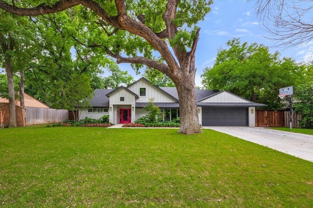 view of front of home with fence, a front yard, board and batten siding, concrete driveway, and an attached garage