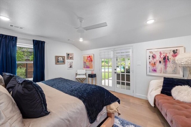 bedroom featuring ceiling fan, visible vents, access to exterior, vaulted ceiling, and wood finished floors