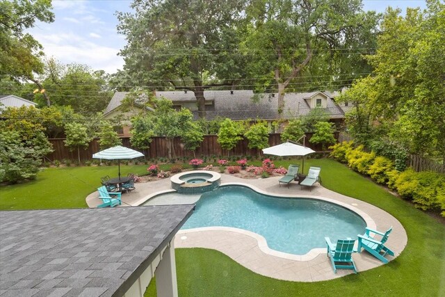 view of pool featuring a lawn, a fenced backyard, a patio area, and a pool with connected hot tub