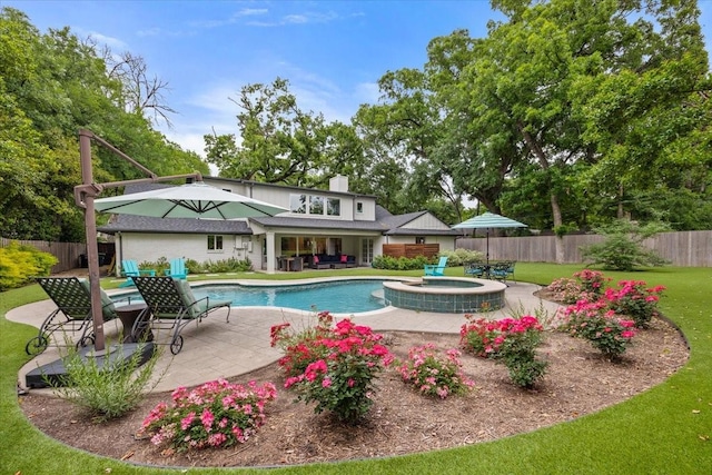 view of pool with a patio area, fence, a yard, and a pool with connected hot tub